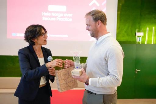 Erlend Andreas Gjære fra Secure Practice mottar prisen av Rehana Schwinninger-Ladak, Head of Unit i European Commission.