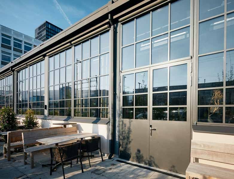 Bronze-grey steel-framed glazed doors and windows with glazing bars on a terrace