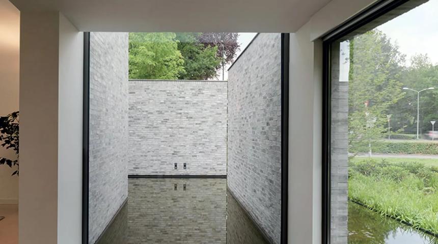 Floor-to-ceiling glass looking into a narrow brick courtyard