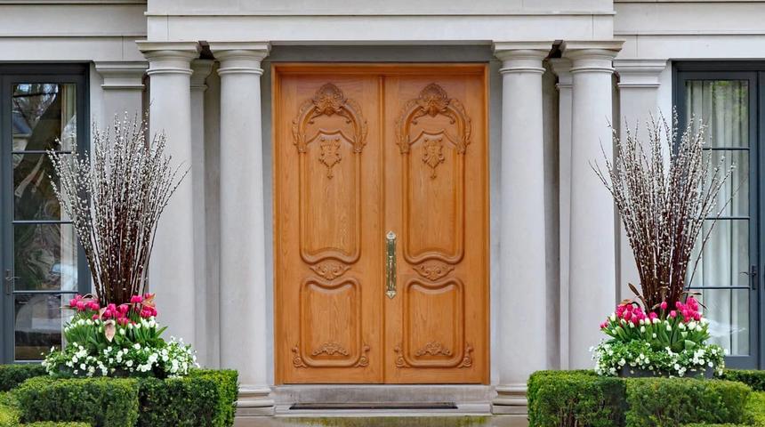 Carved timber double doors between stone columns