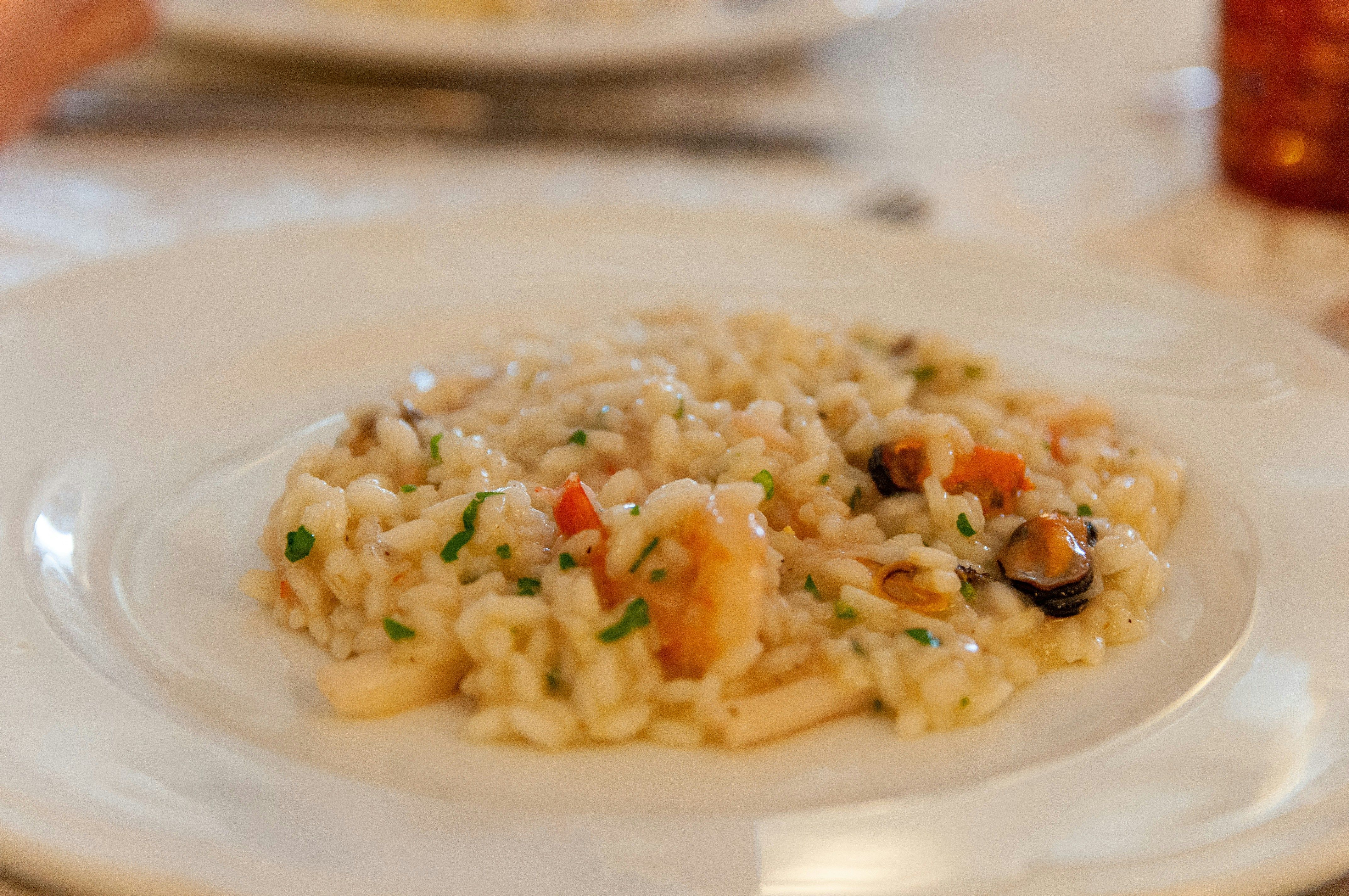 Risotto con piselli verdi su piatto bianco