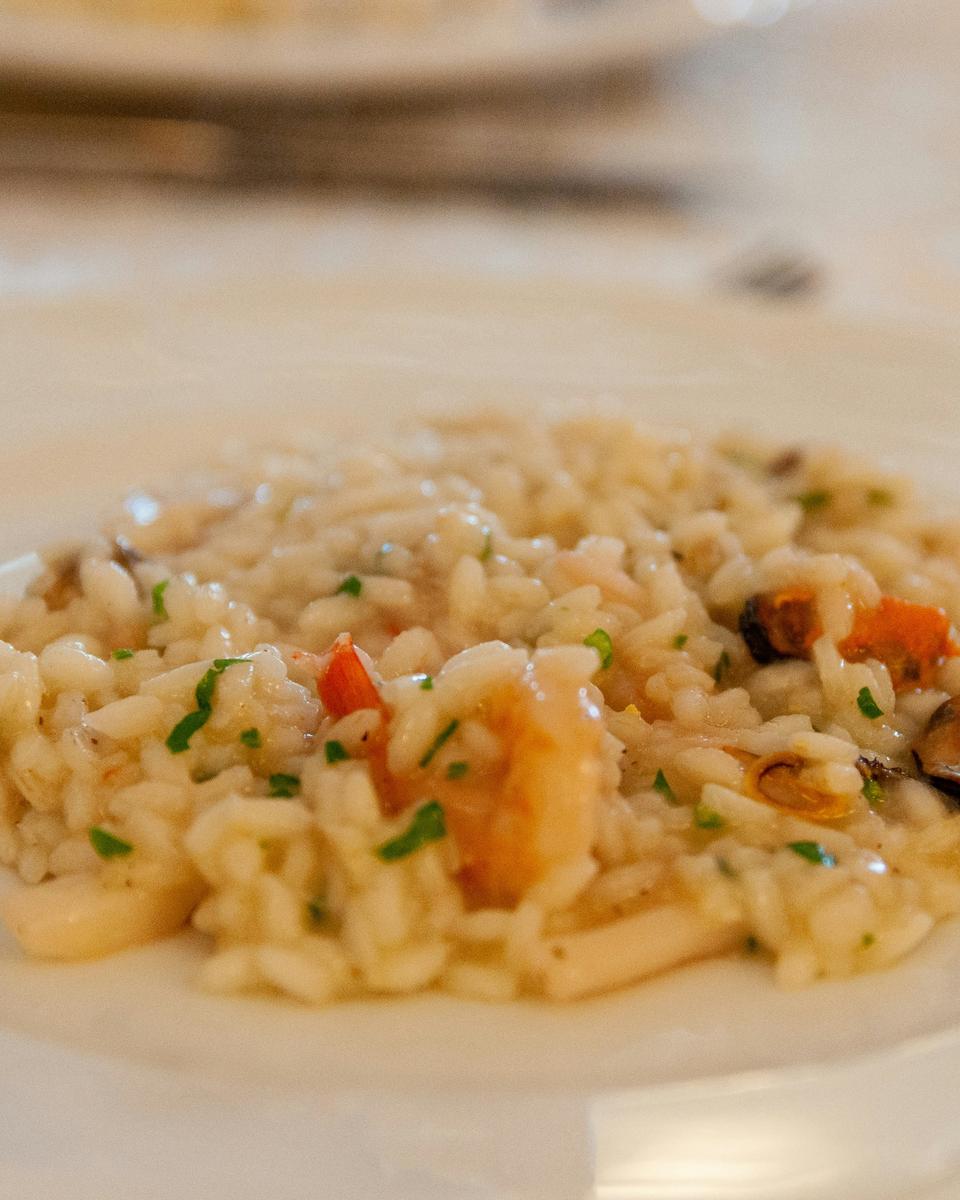 Risotto con piselli verdi su piatto bianco