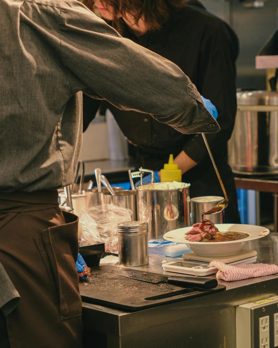Chef plating un piatto fine dining in cucina