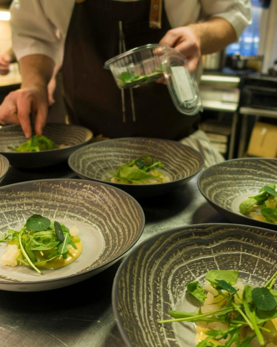 Chef prepara un piatto in cucina professionale