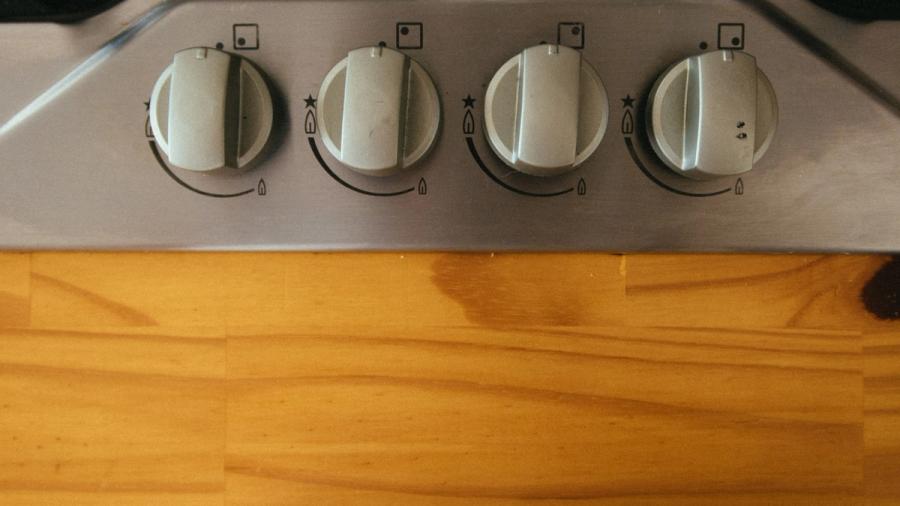 Close-up of four control knobs on a gas stove at toddler height