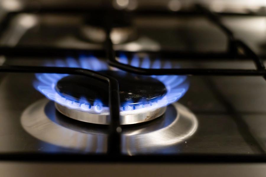 Blue flame burning on a home gas stovetop burner, illustrating gas cooking safety