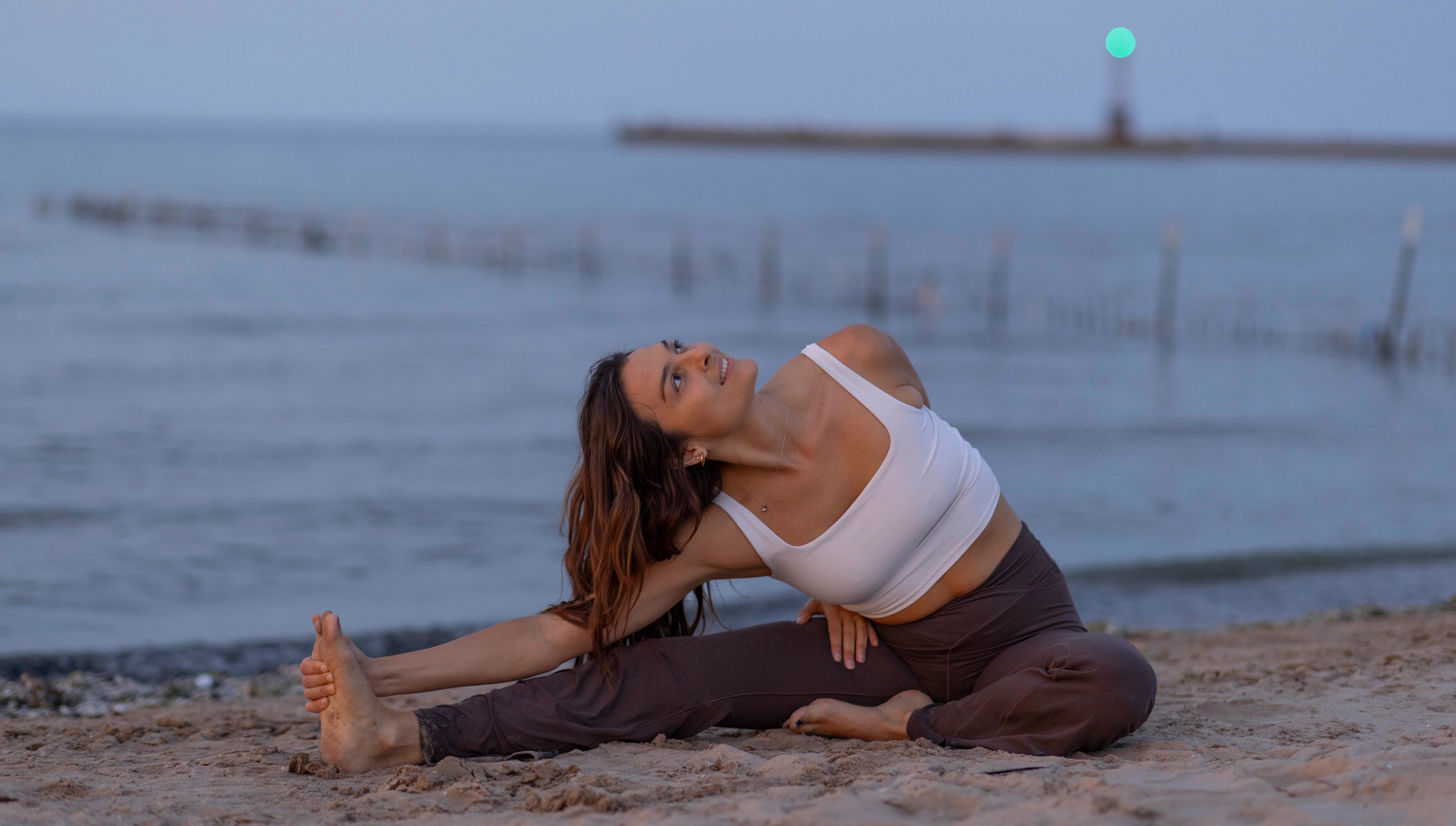 Ali performing yoga pose on beach