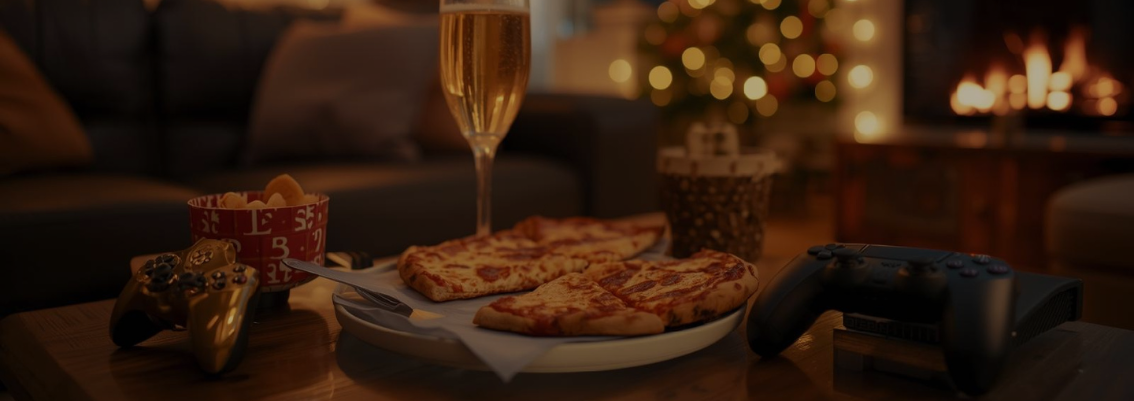 Suasana ruang tamu nyaman dengan cemilan pizza dan game console untuk merayakan malam tahun baru di rumah.
