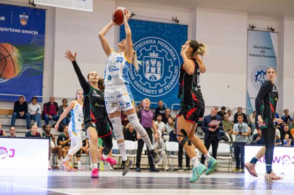 Jovana Popović (33) oddaje rzut nad wyciągniętymi rękami zawodniczek Zagłębia.