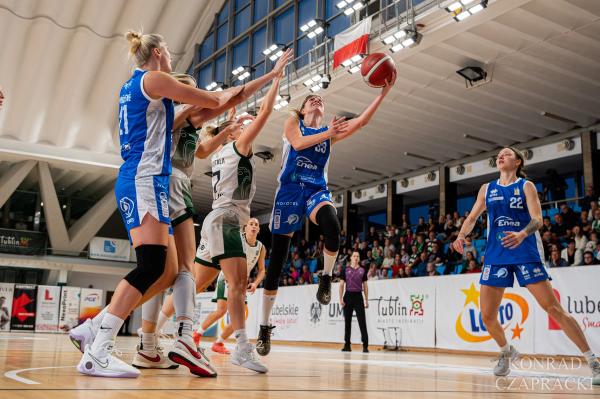 Zawodniczka Enea AZS wchodzi pod kosz, obok Laura Miškinienė (21) i Anna Jakubiuk (22).