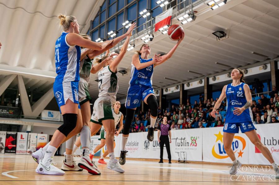 Zawodniczka Enea AZS wchodzi pod kosz, obok Laura Miškinienė (21) i Anna Jakubiuk (22).