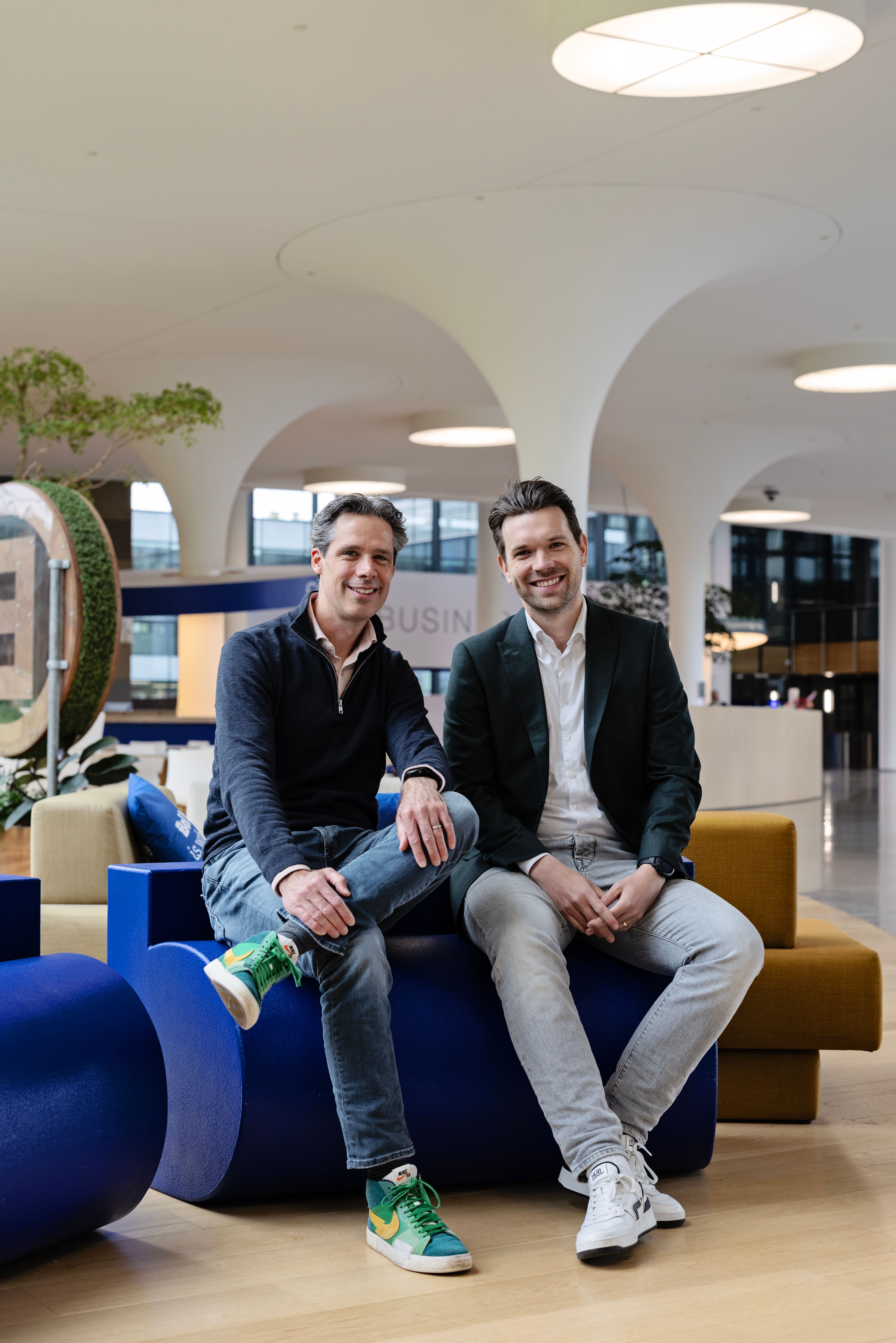 Justin Sandee en Koen van den Eeden (Flywheel NL) zitten in de hal van het hoofdkantoor van bol