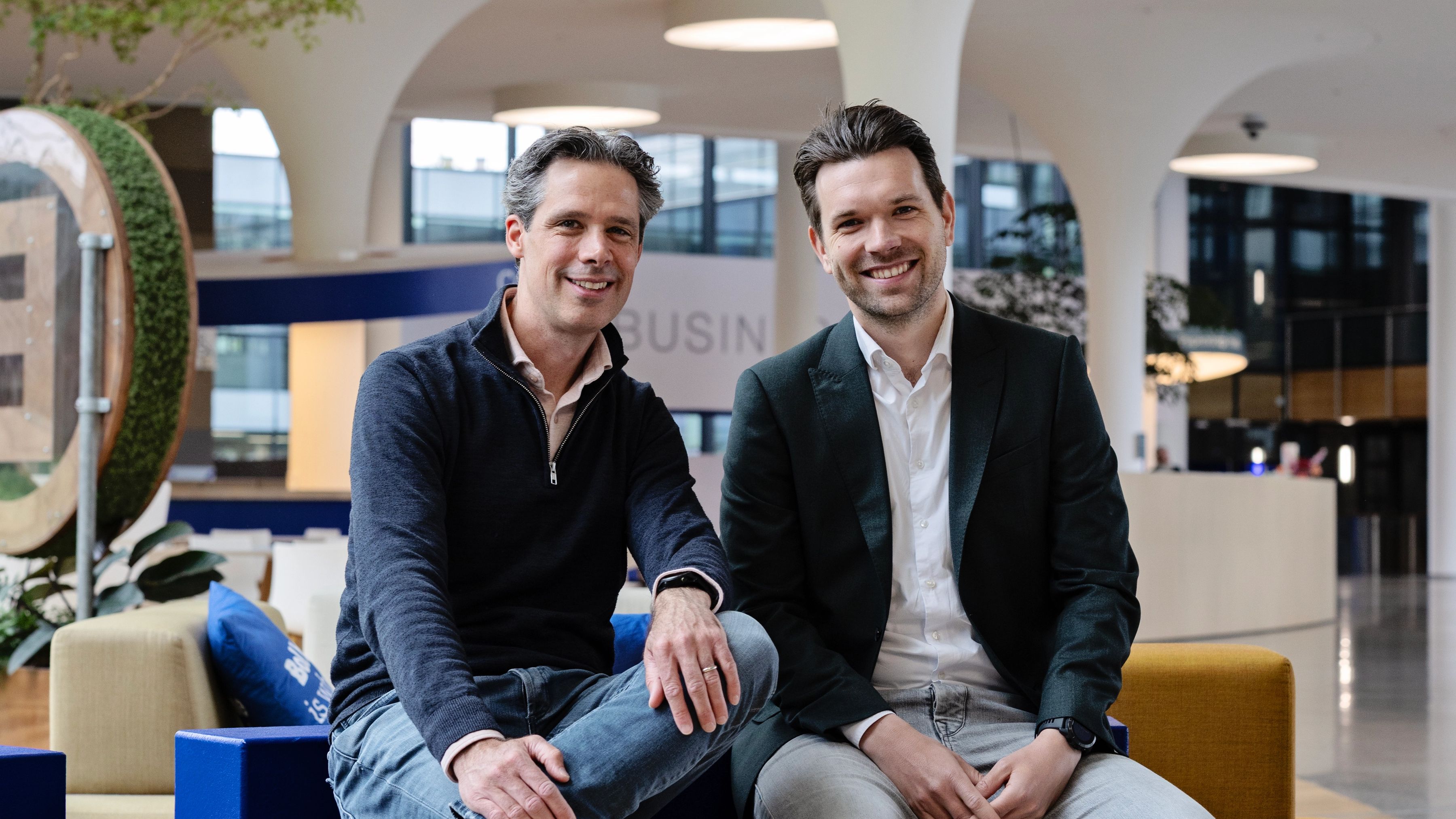 Justin Sandee en Koen van den Eeden (Flywheel NL) zitten in de hal van het hoofdkantoor van bol