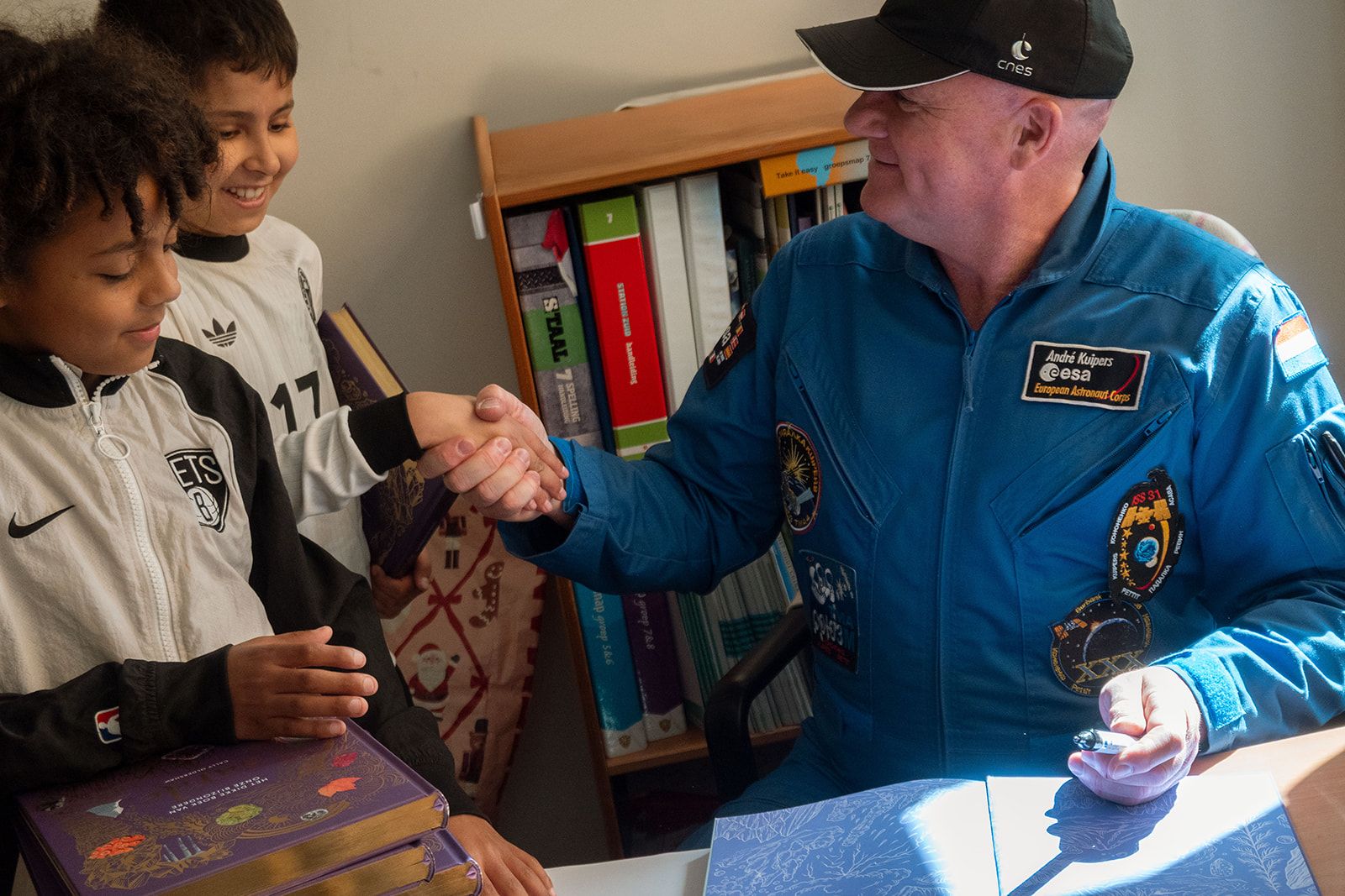 Andre Kuipers signeert boeken in de klas