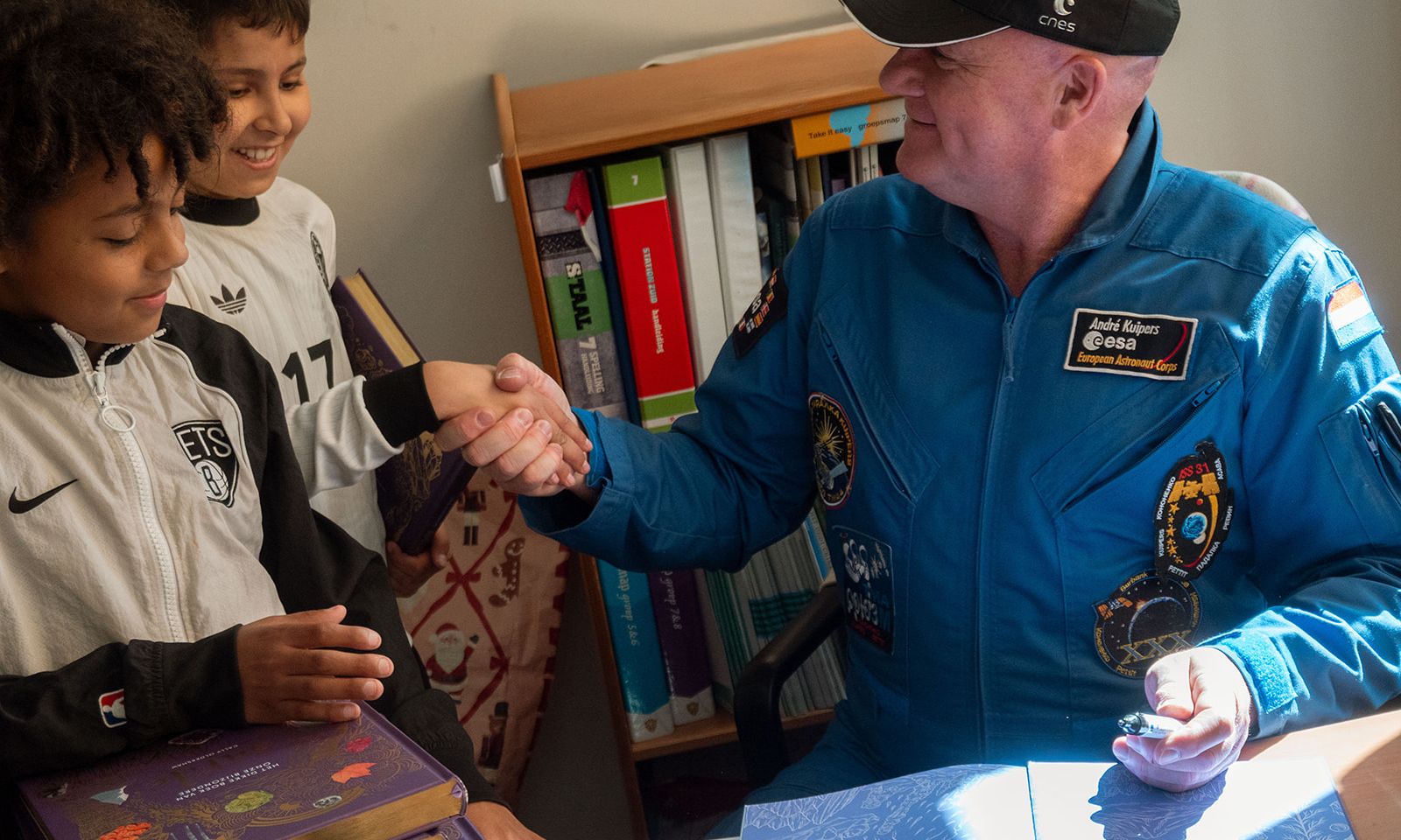 Andre Kuipers signeert boeken in de klas