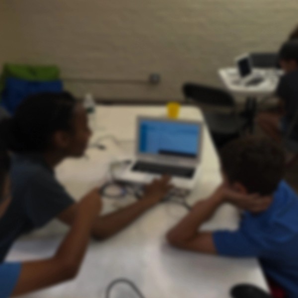 Kids learning how to code on a portable computer