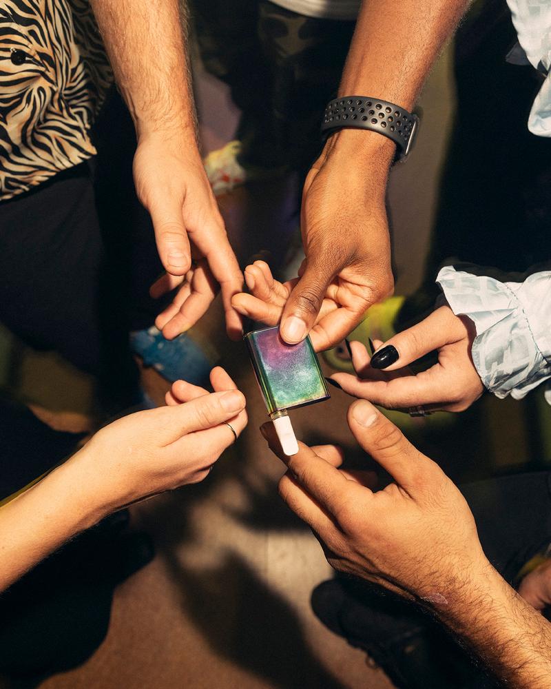 group in club setting passing vape