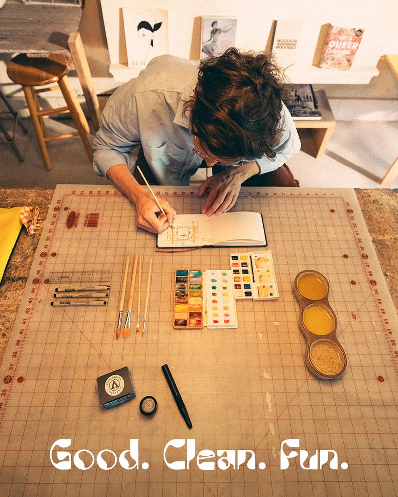 artist at a table with tagline