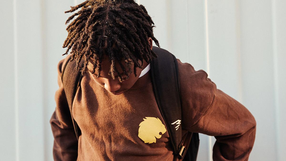 Male student in branded sweatshirt wearing backpack