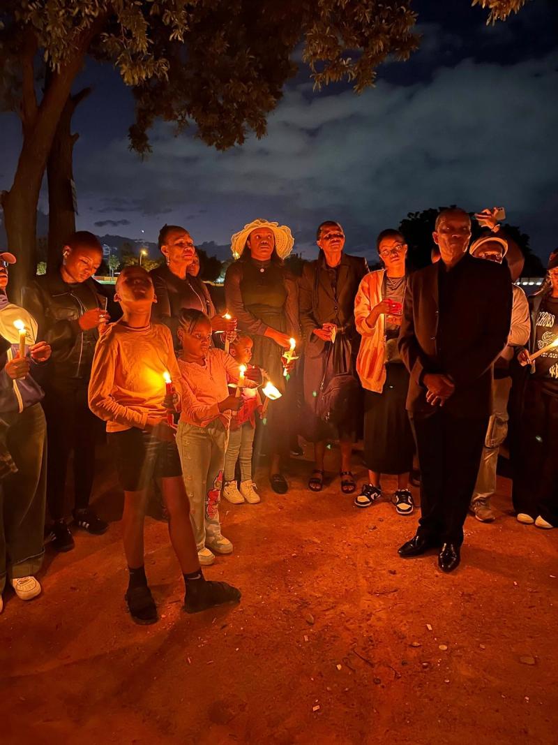 Families and students hold candles together at the Candlelight Justice gathering.