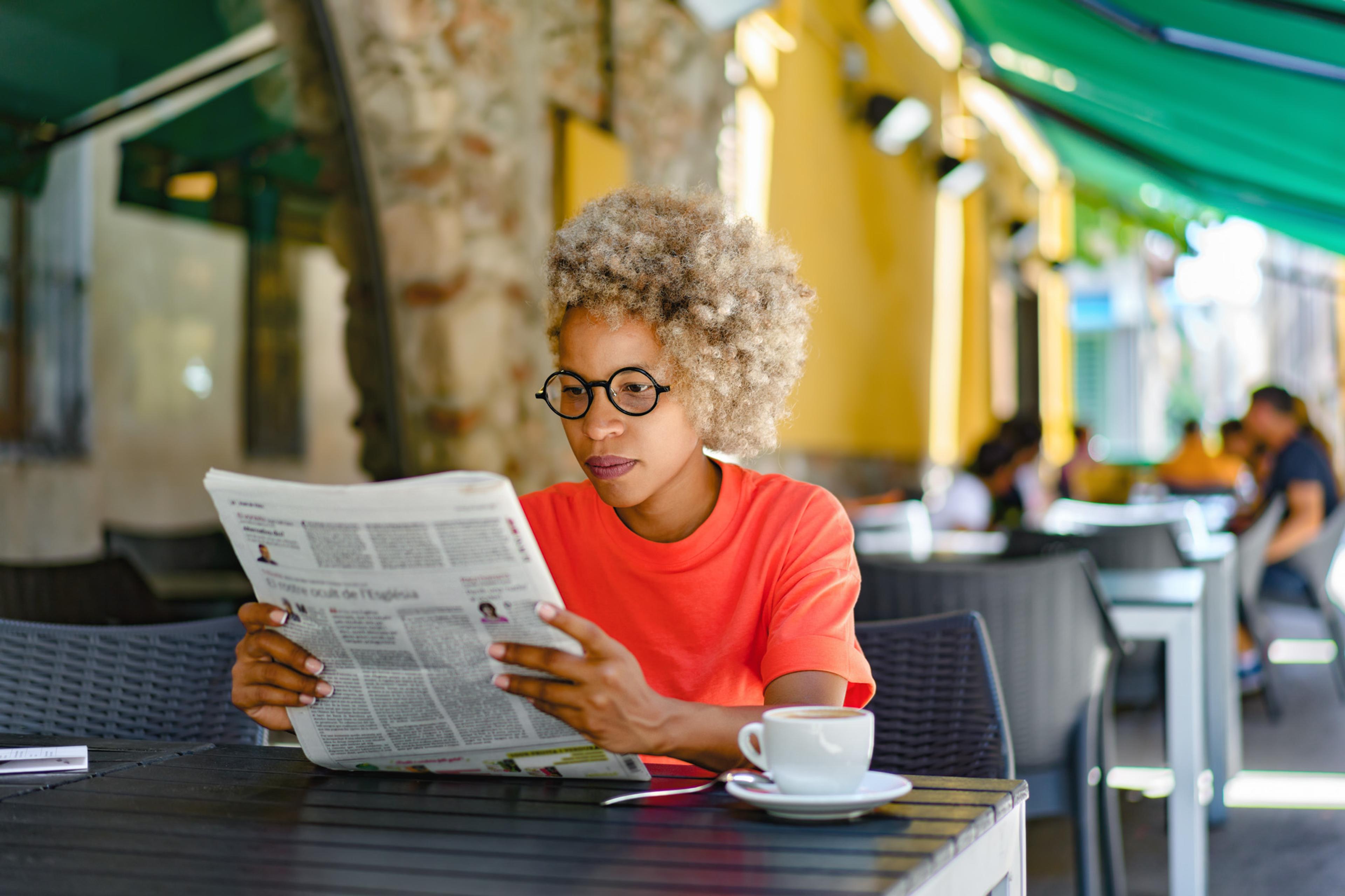 Female professional enjoying coffee and reading the newspaper