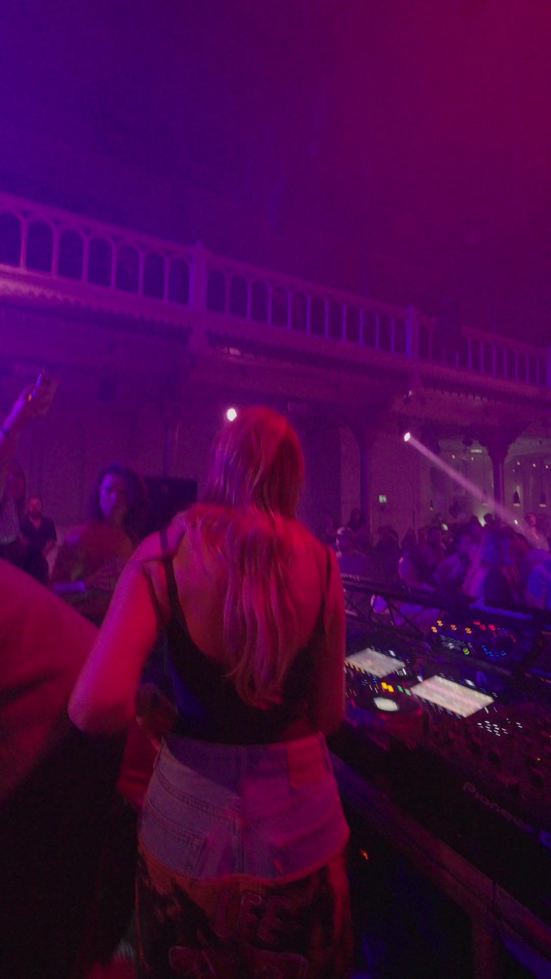 DJ with the room and balcony behind