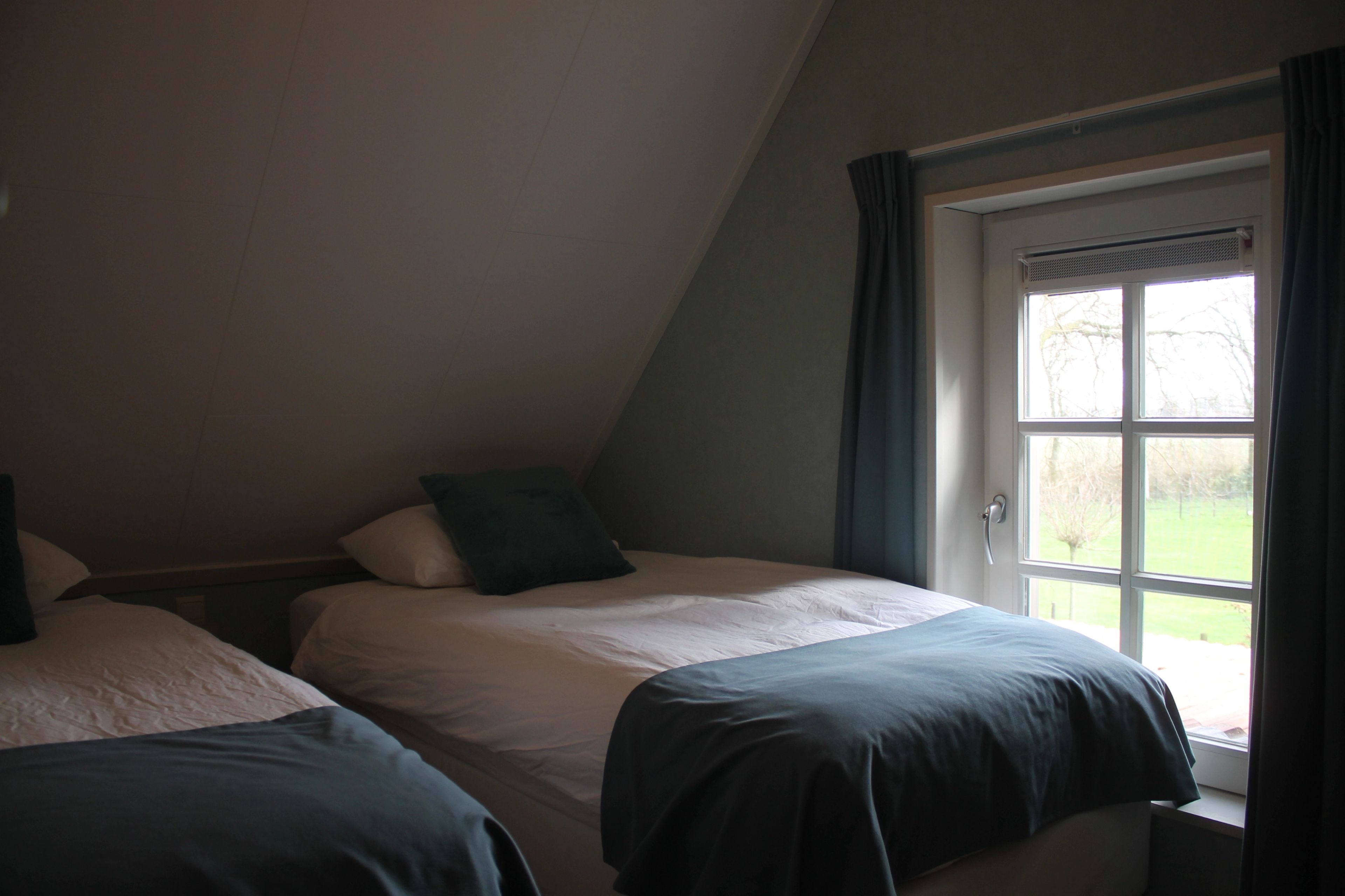 Slaapkamer in een vakantiewoning met uitzicht over het groen
