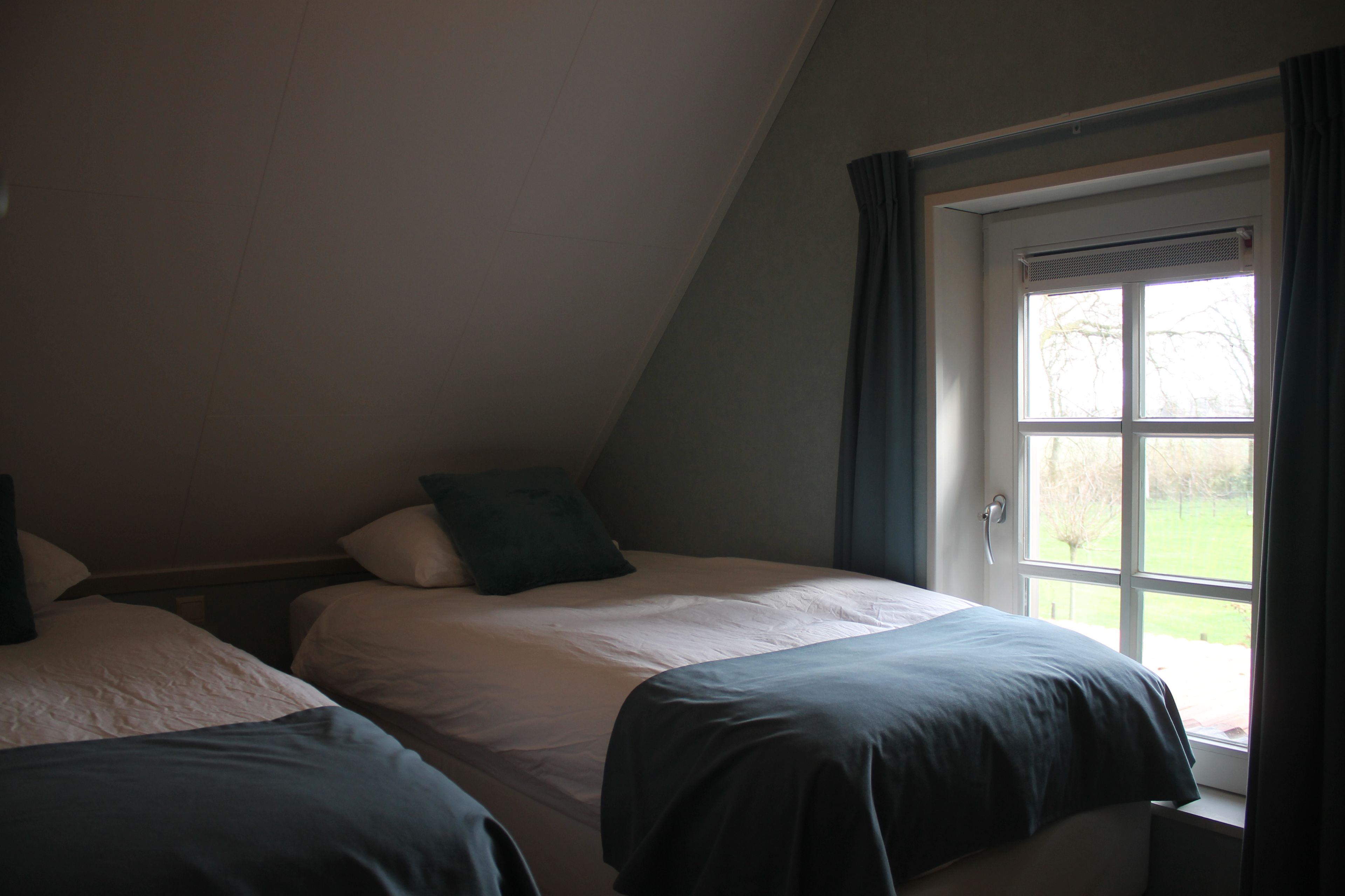 Slaapkamer in een vakantiewoning met uitzicht over het groen
