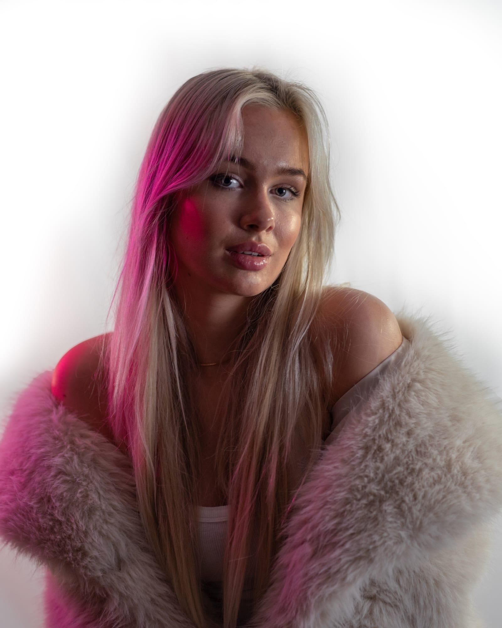 Beauty portrait with a pink hair streak and fur coat