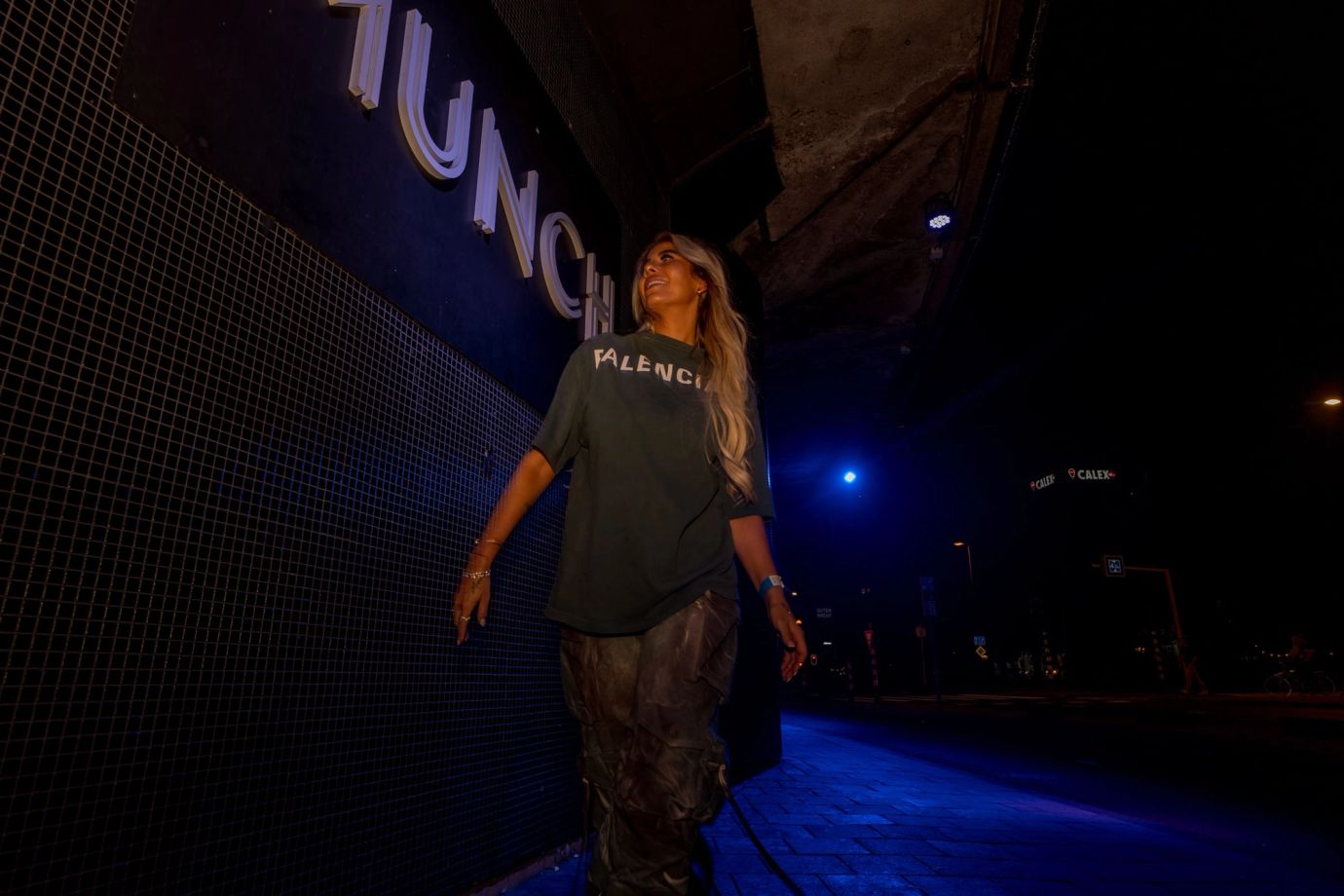 Guest walking past the lit club facade