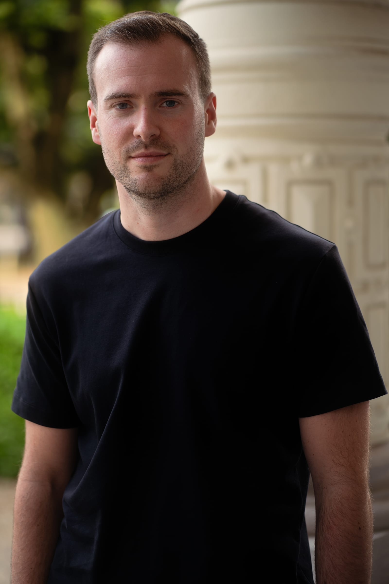 Entrepreneur in a black T-shirt next to a column