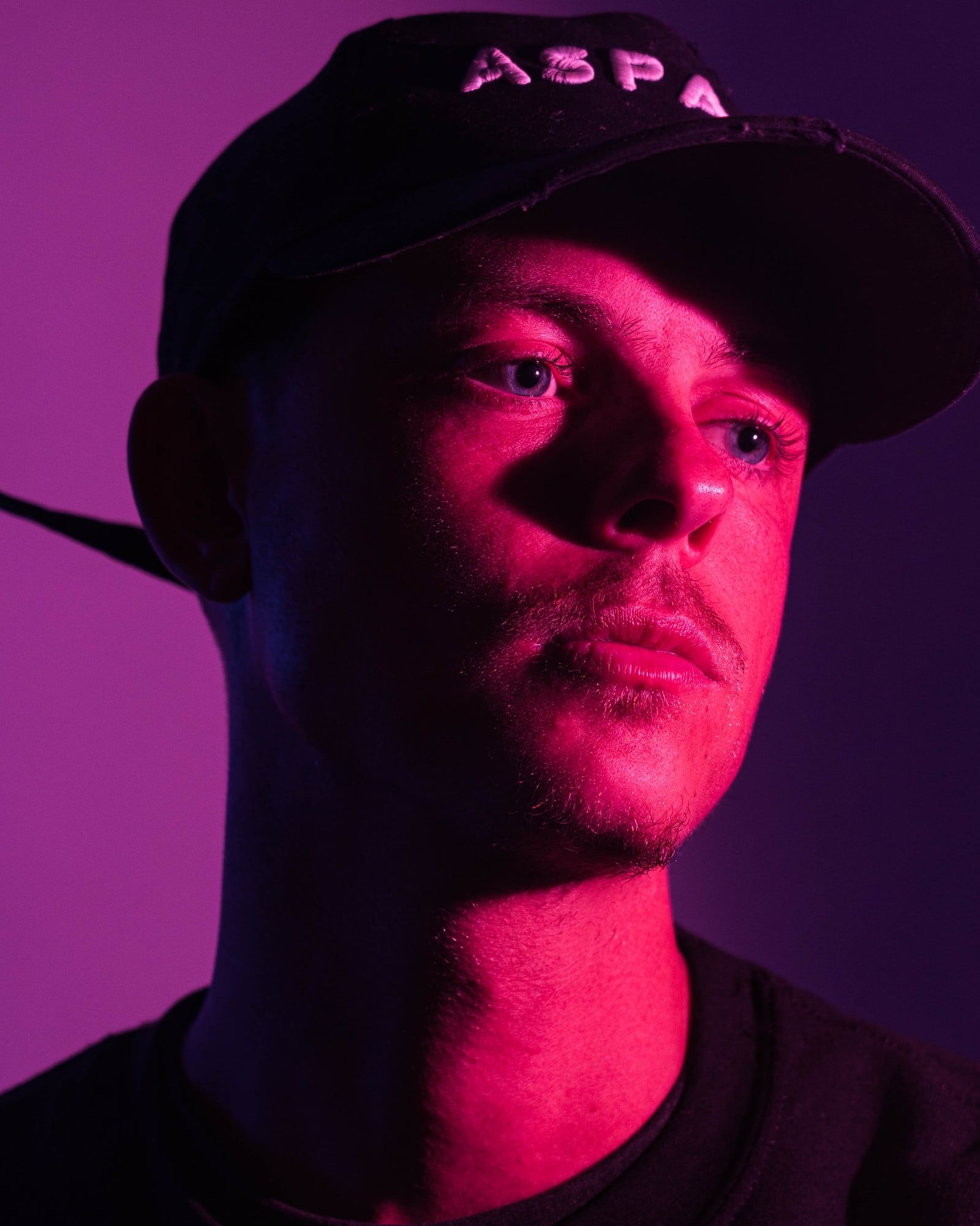 Ian wearing a cap in pink light