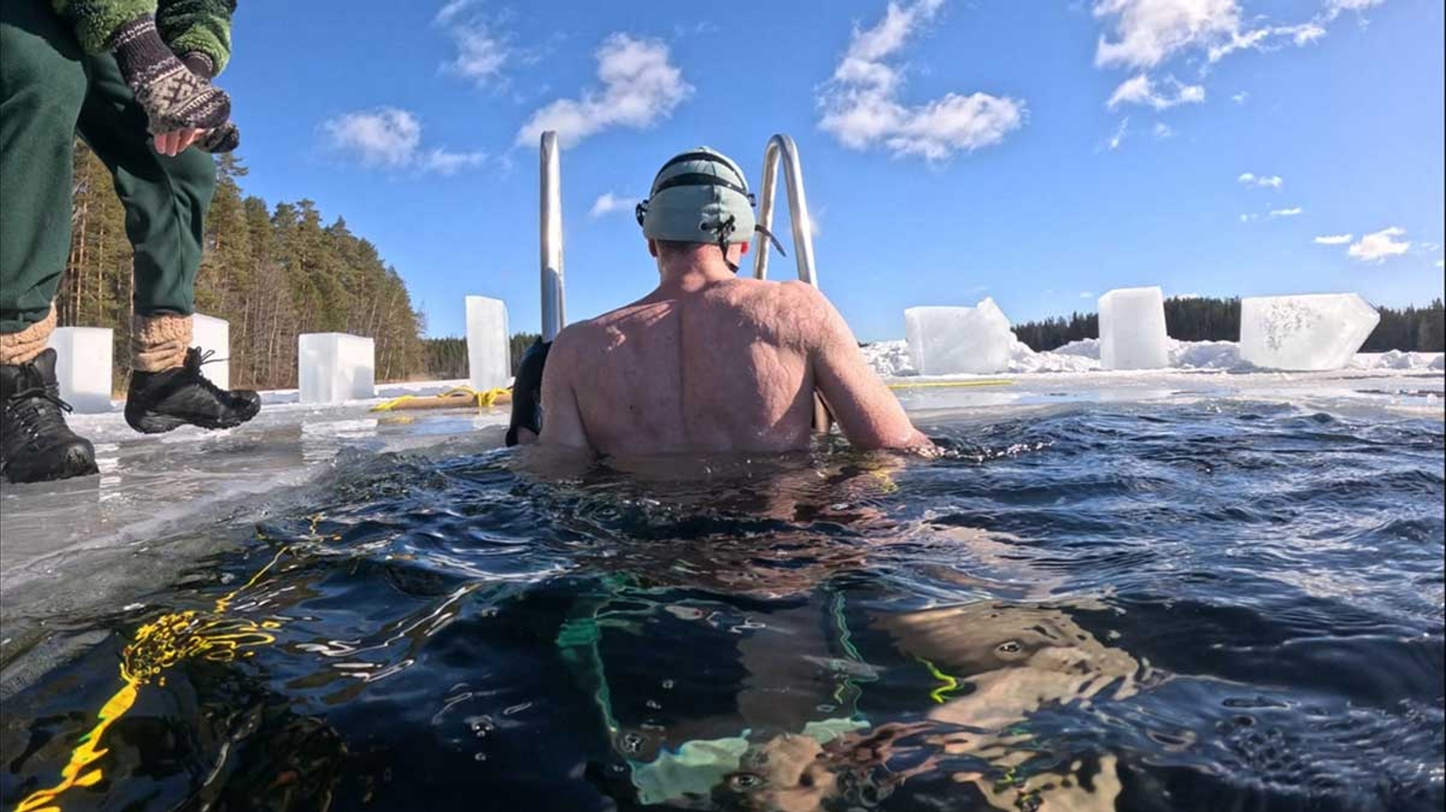 Bojan diving under the frozen lake in Finland