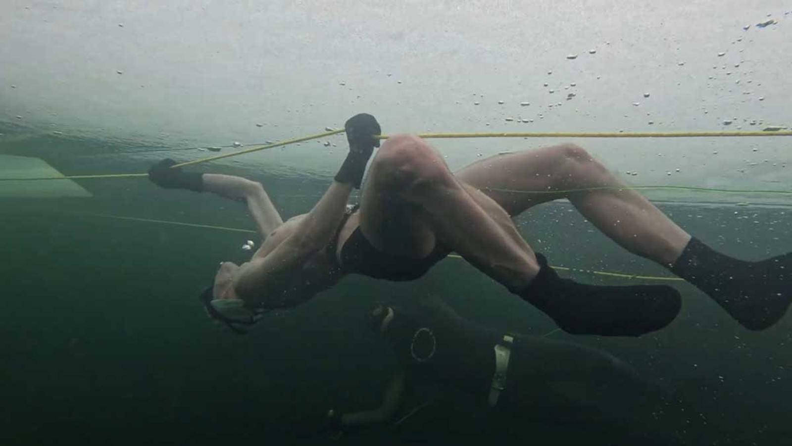 Bojan diving under the frozen lake in Finland