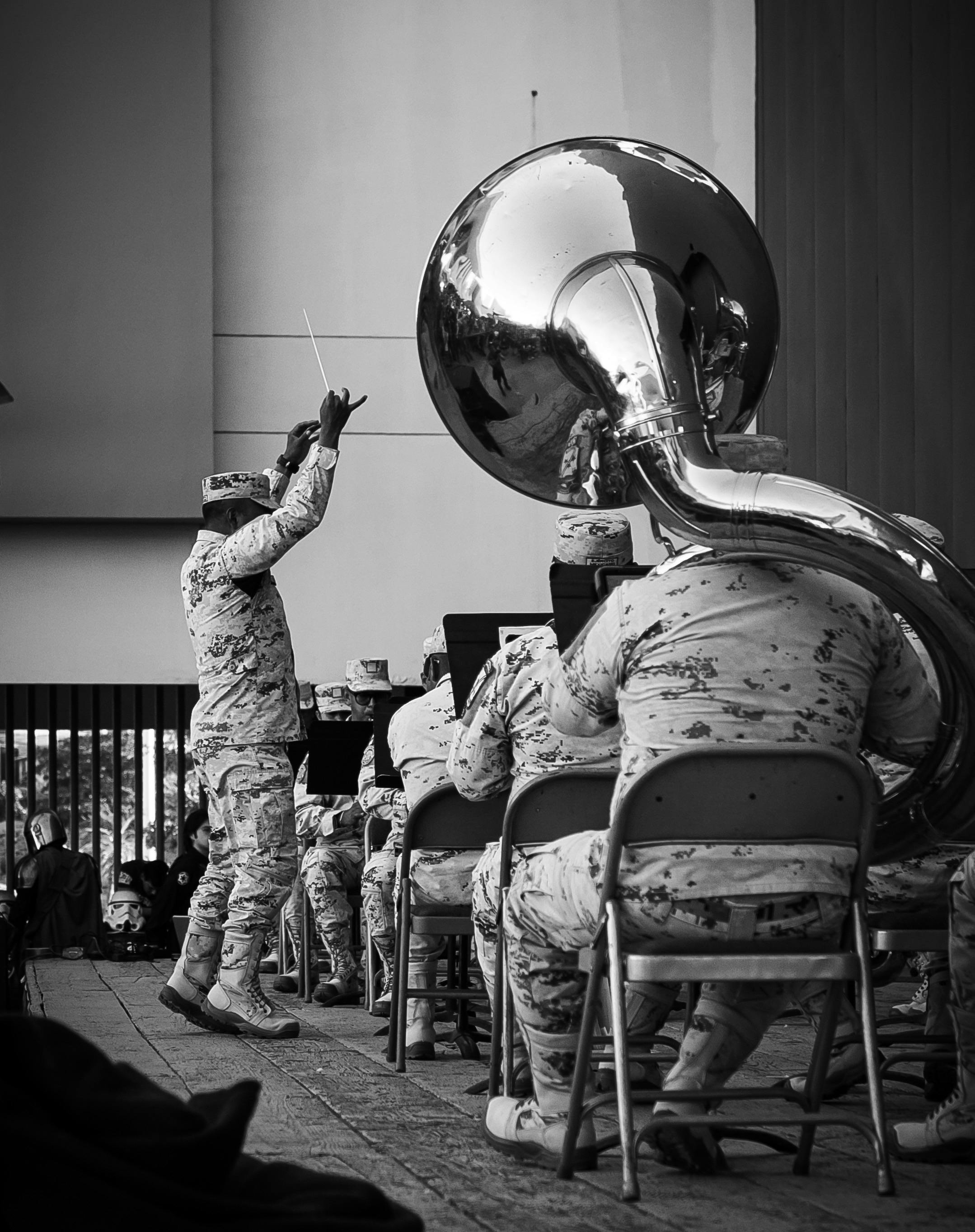 People sitting in chairs playing different instruments while dressed in military uniforms