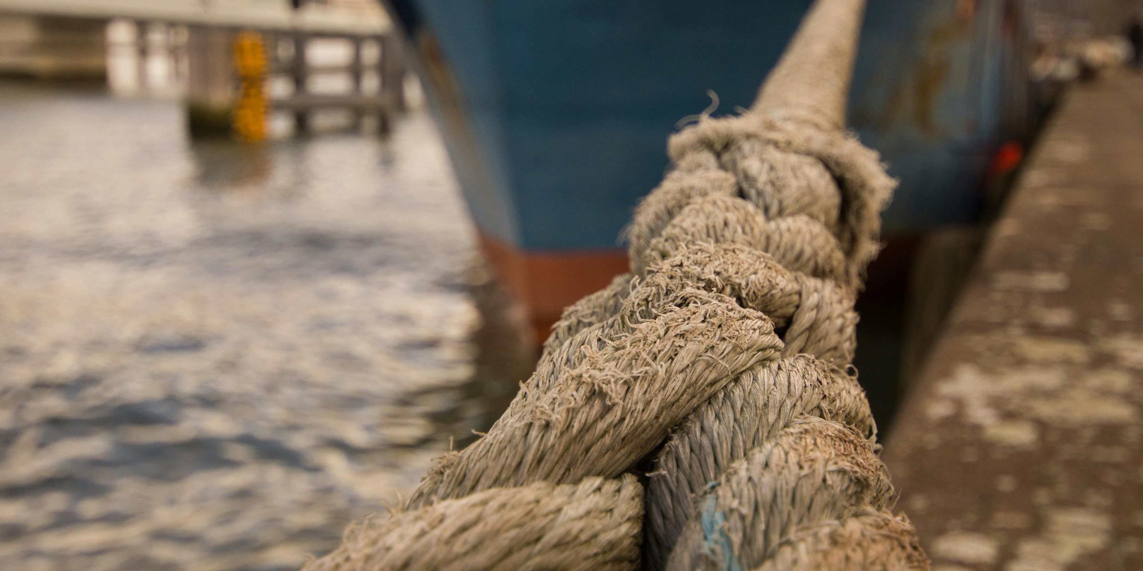 Ship in port tied with large ropes