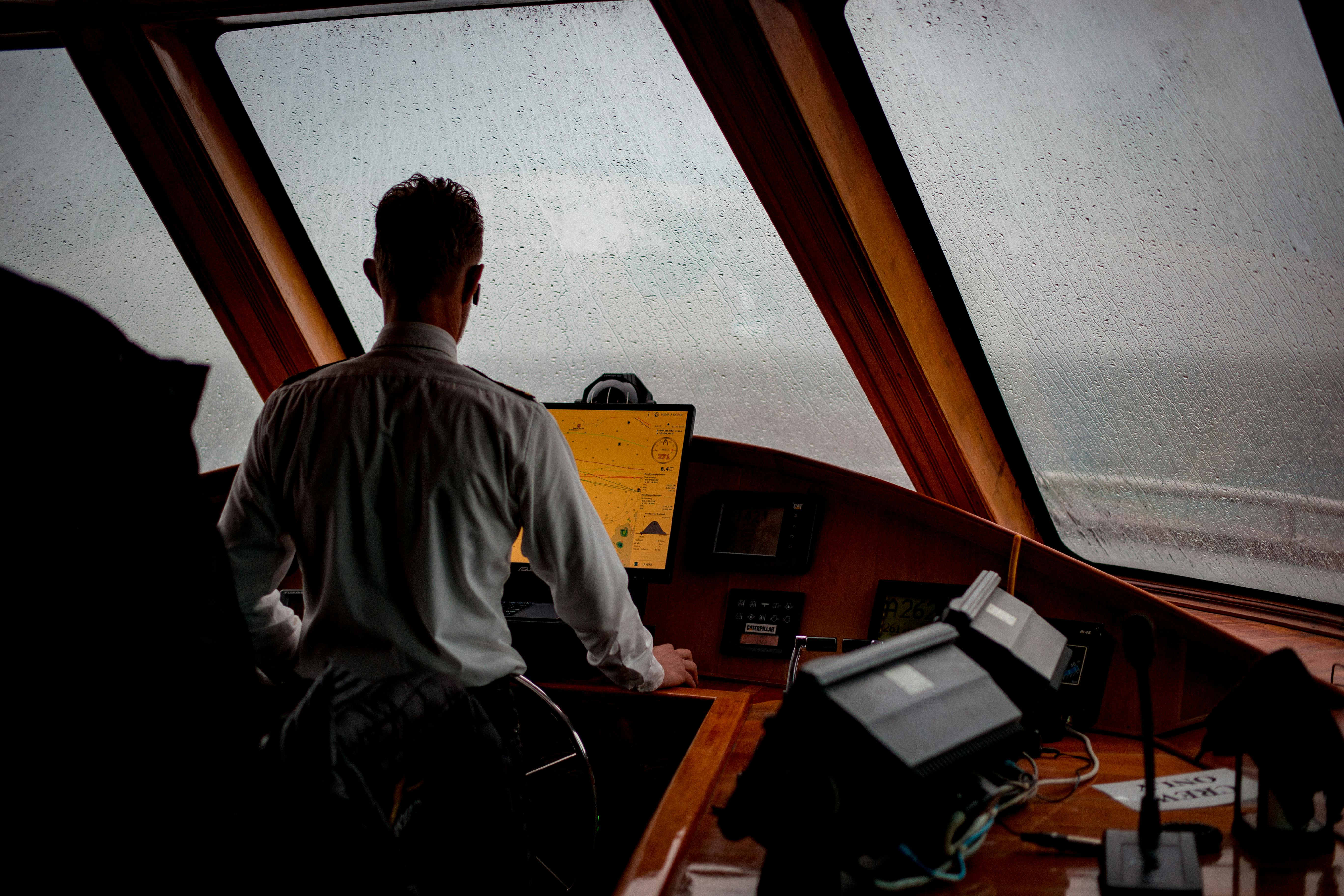Captain at the controls, navigating through rainy seas.