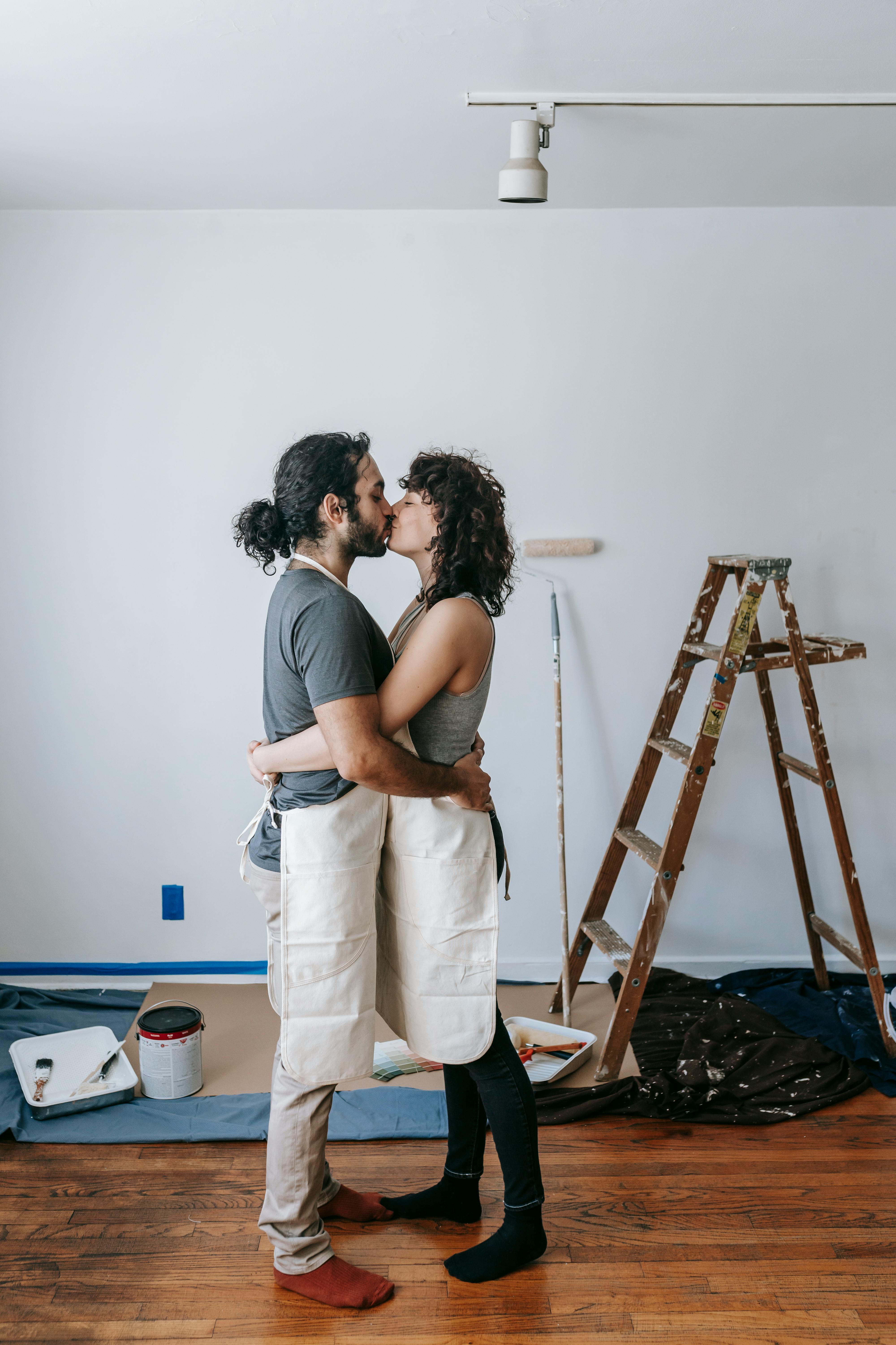 Couple sharing a kiss while doing a home improvement project