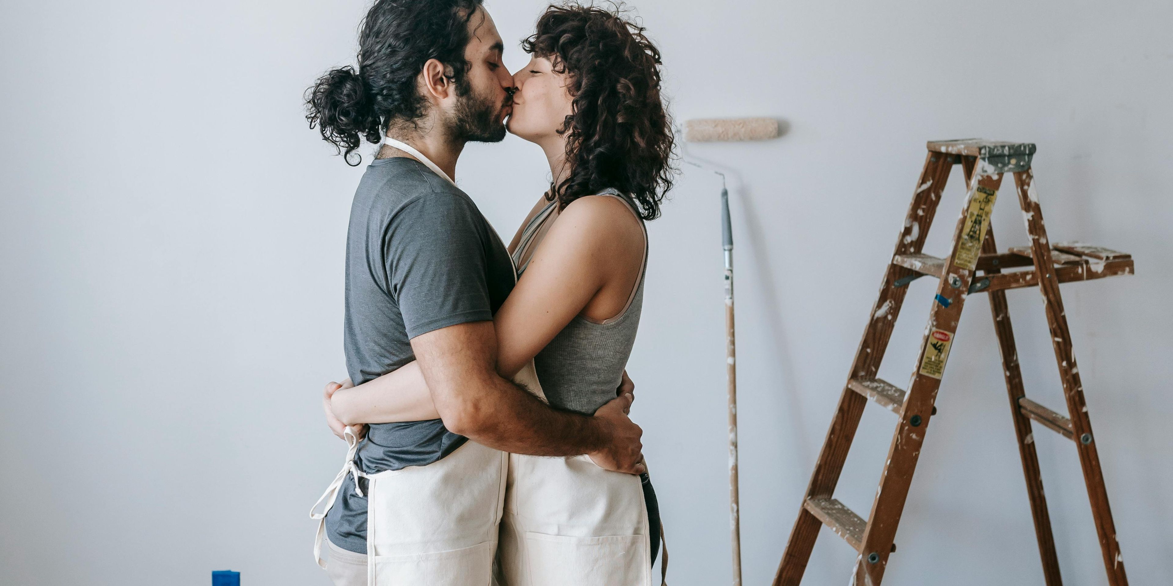 Couple sharing a kiss while doing a home improvement project