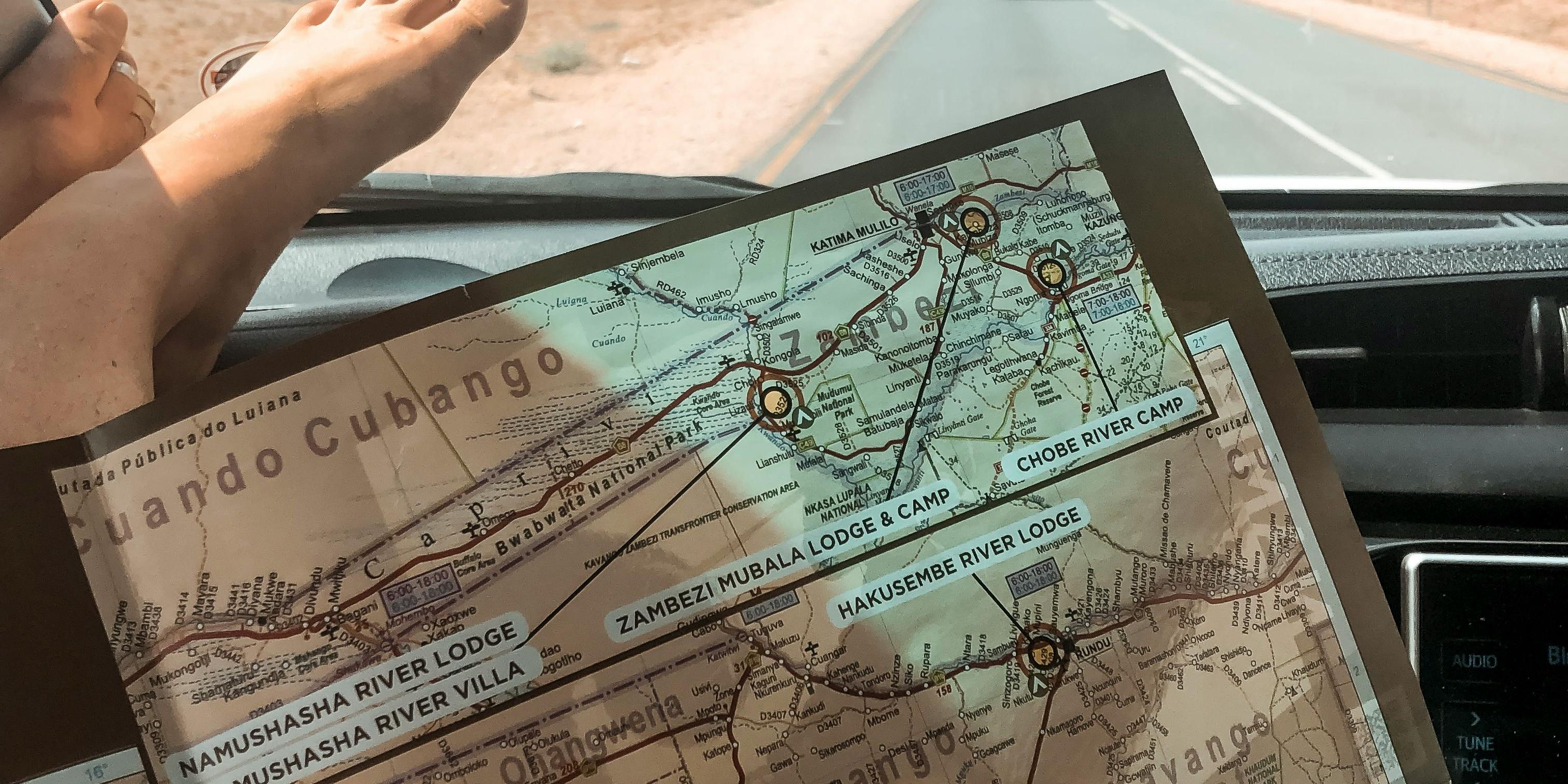 Passanger riding with their feet up on the highway while holding a map