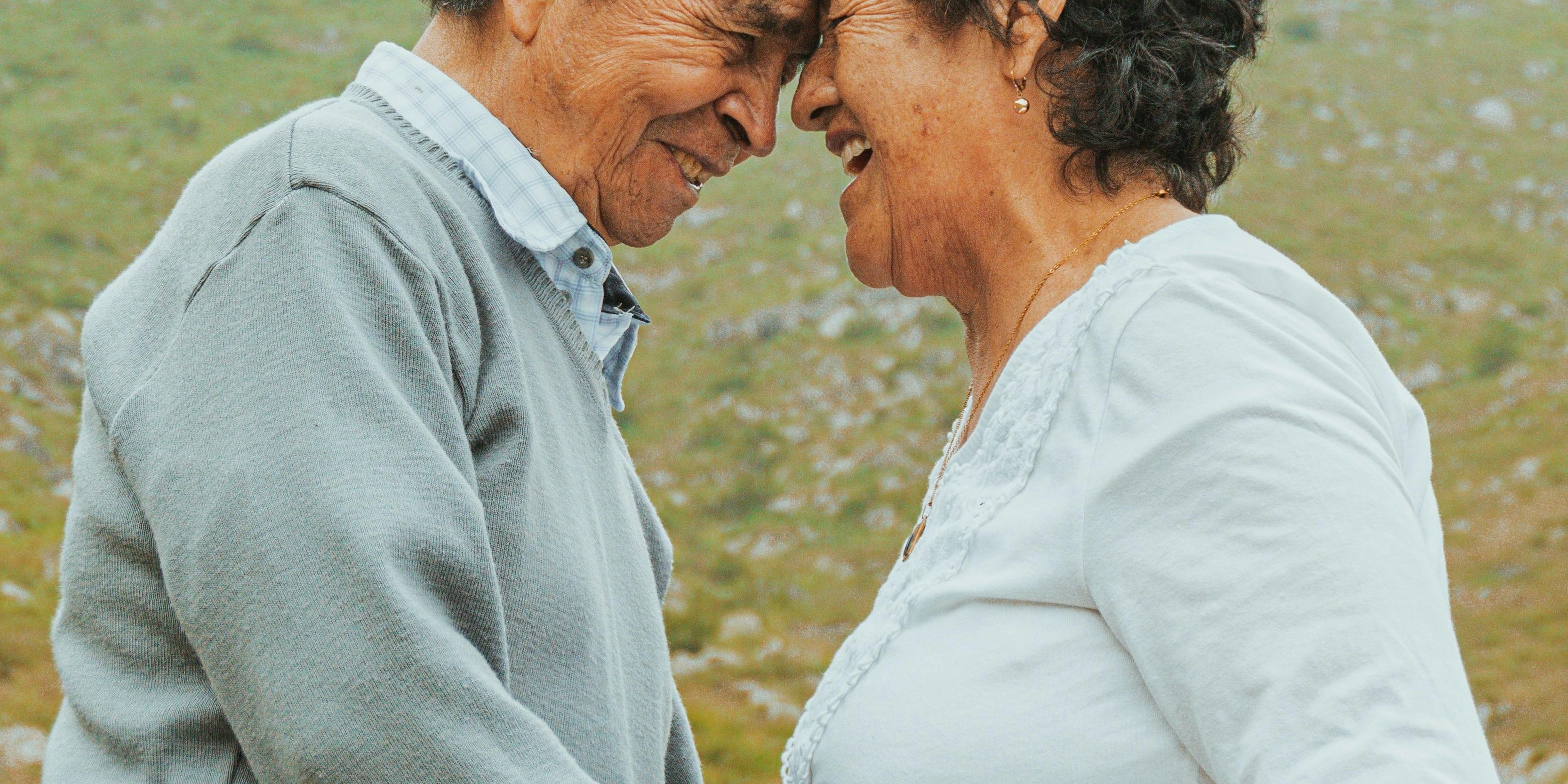 Older couple holding hands and intimately resting on each others foreheads