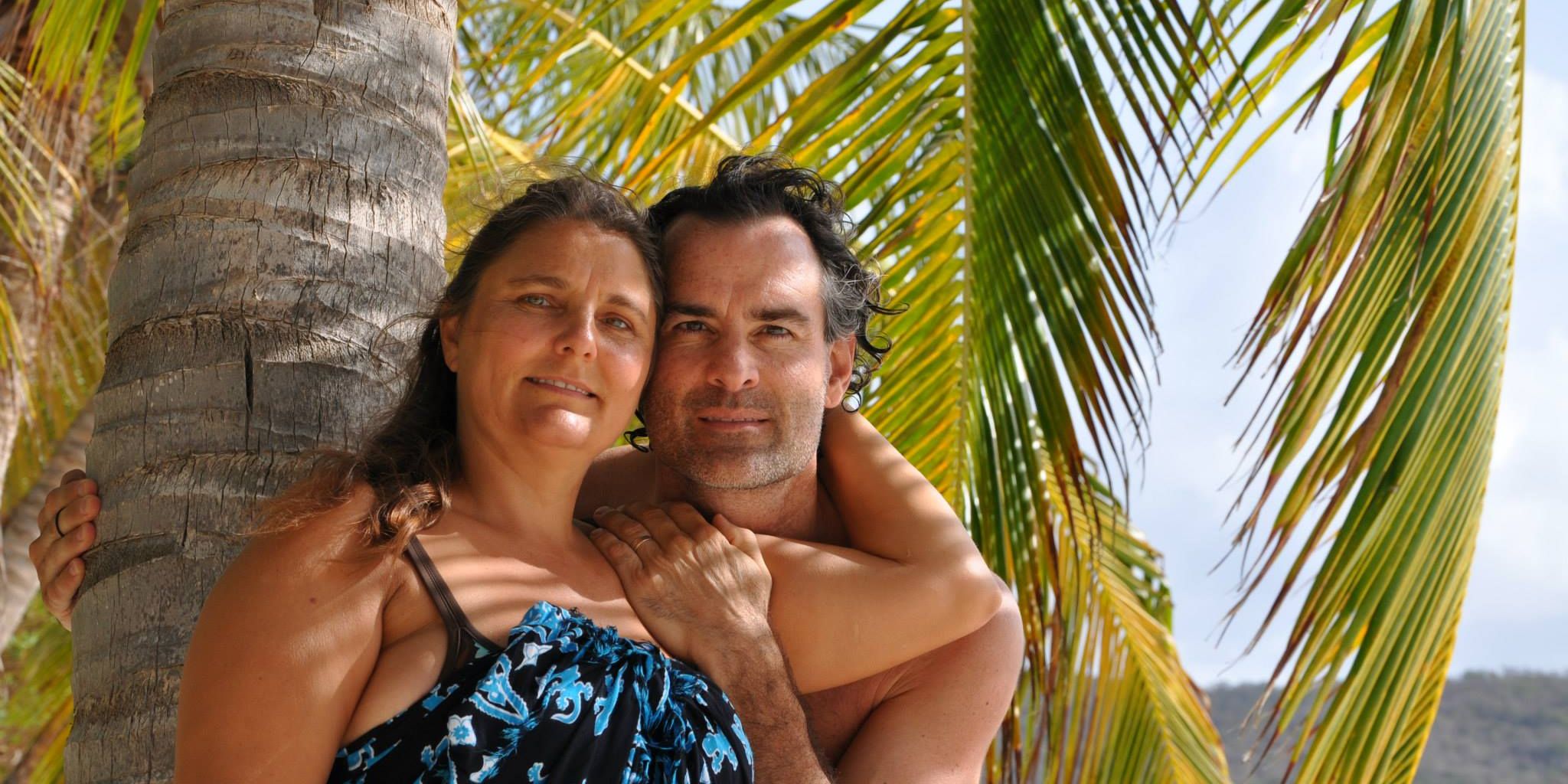 Terri & Curtis Krupp posing in front of a palm tree