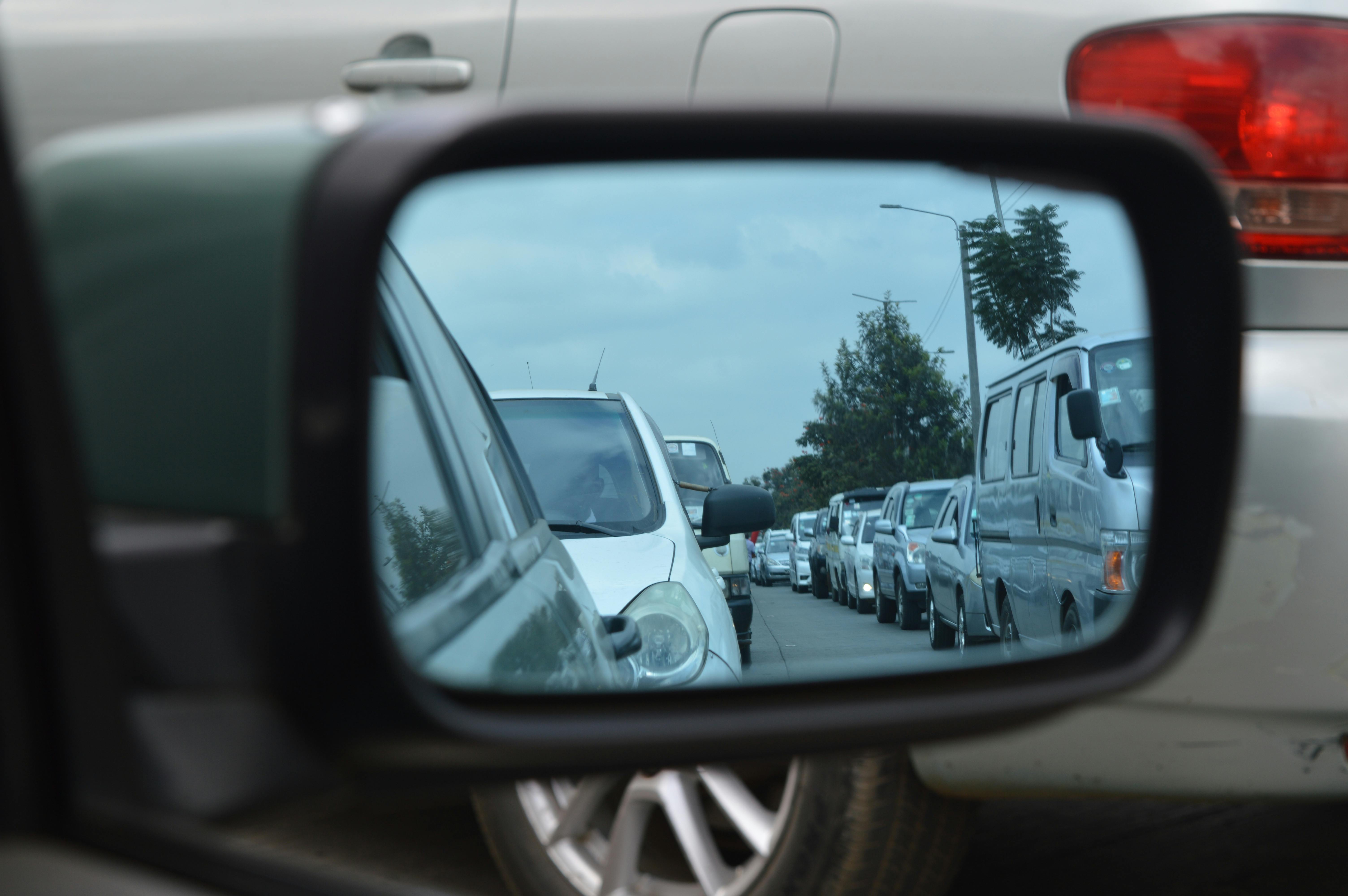 View of the rearview mirror showing a long line of traffic piling up 