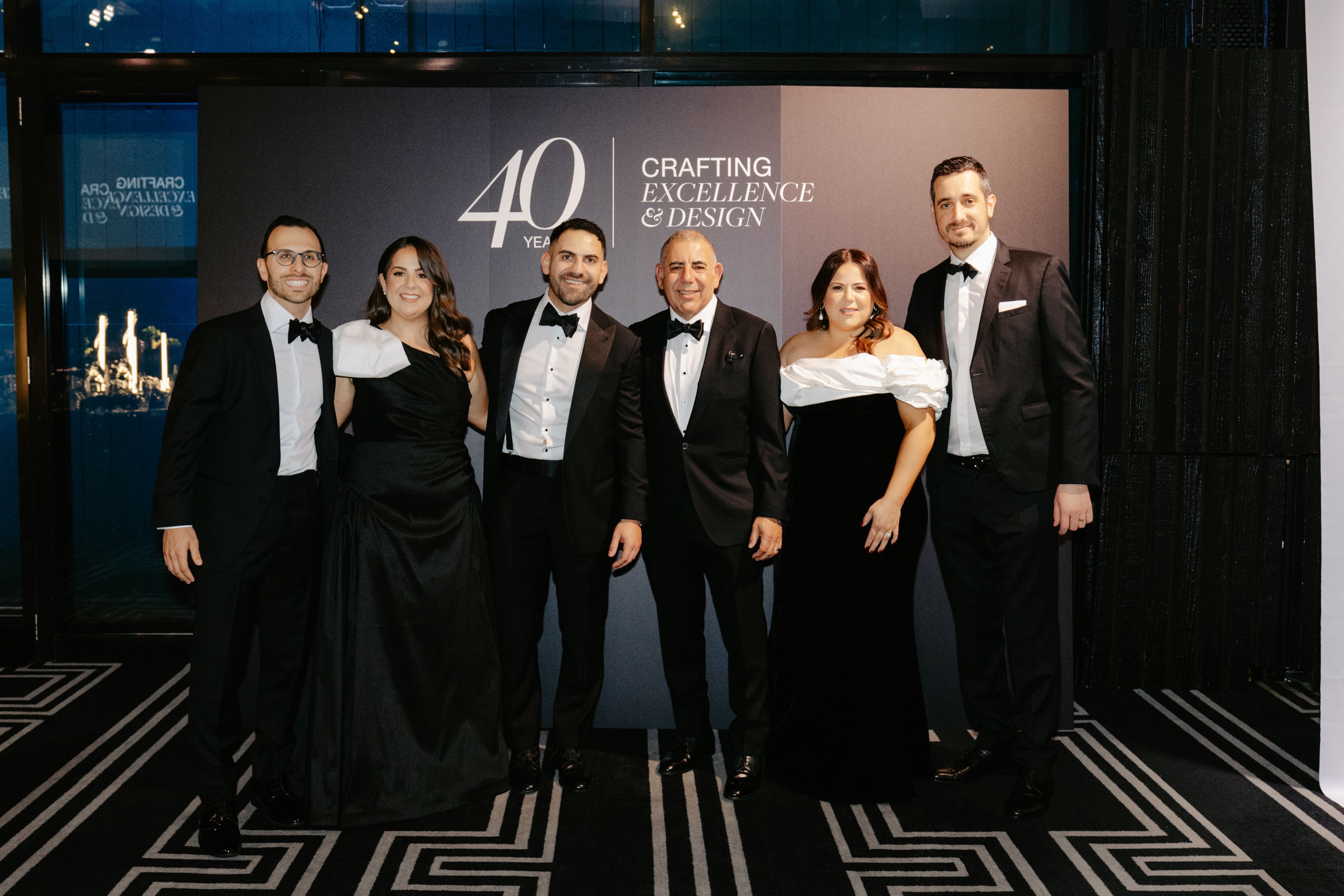 The Timpelle Kitchens team in black tie at the branded 40 Years anniversary backdrop in Sydney