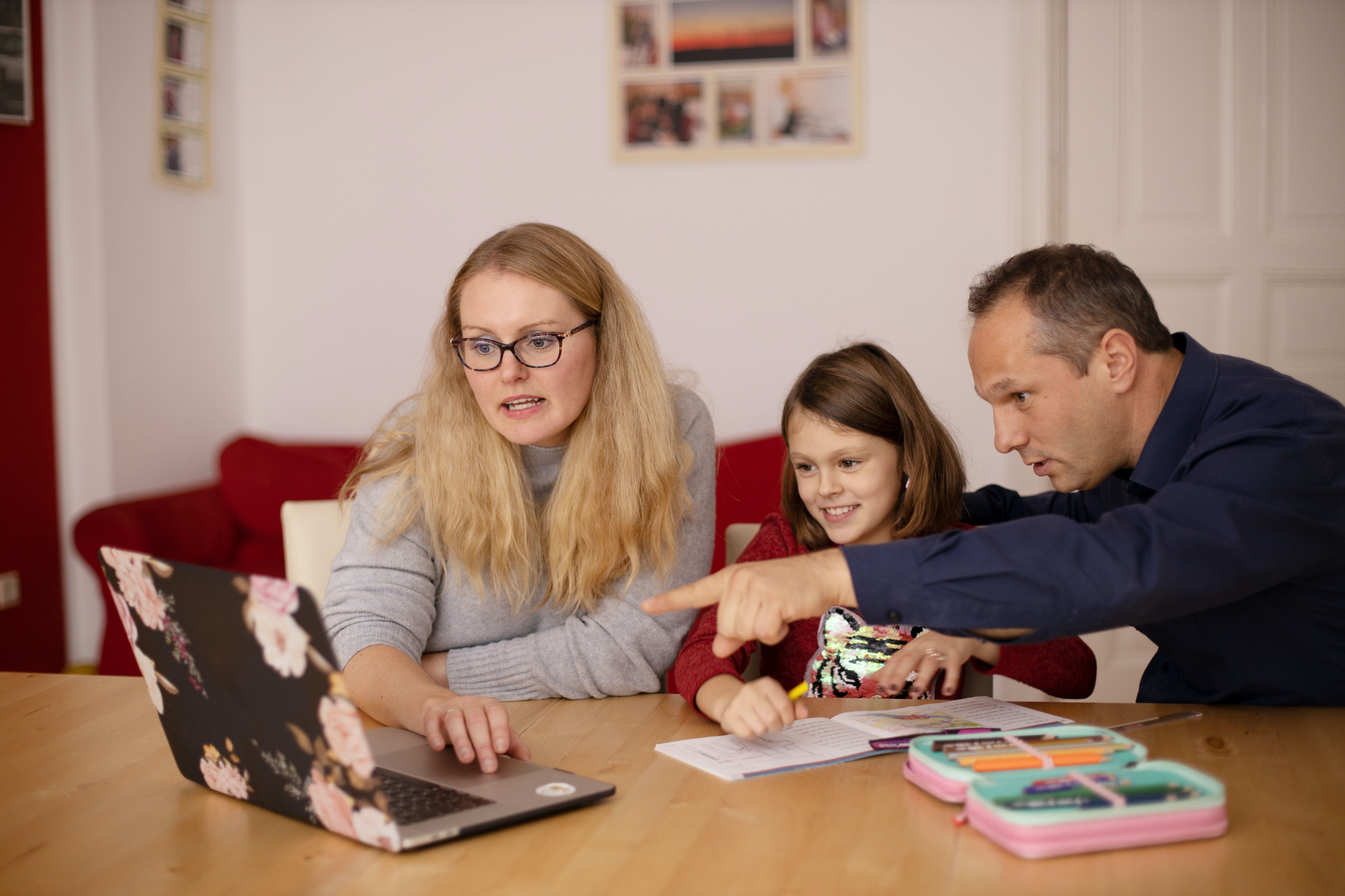 Adults helping a child with homework online.