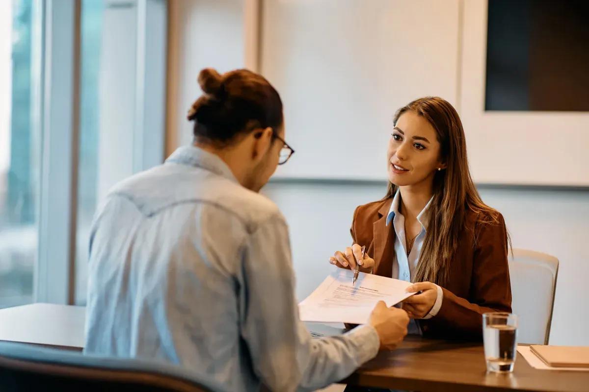 A man and a woman are sitting at a table having a job interview