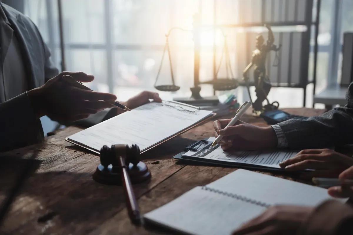 A group of people are sitting at a table signing a document