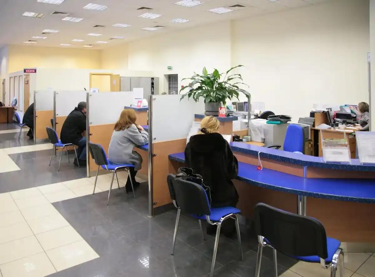A woman is sitting at a counter in a bank