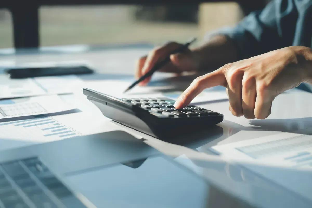 A person is using a calculator on a table