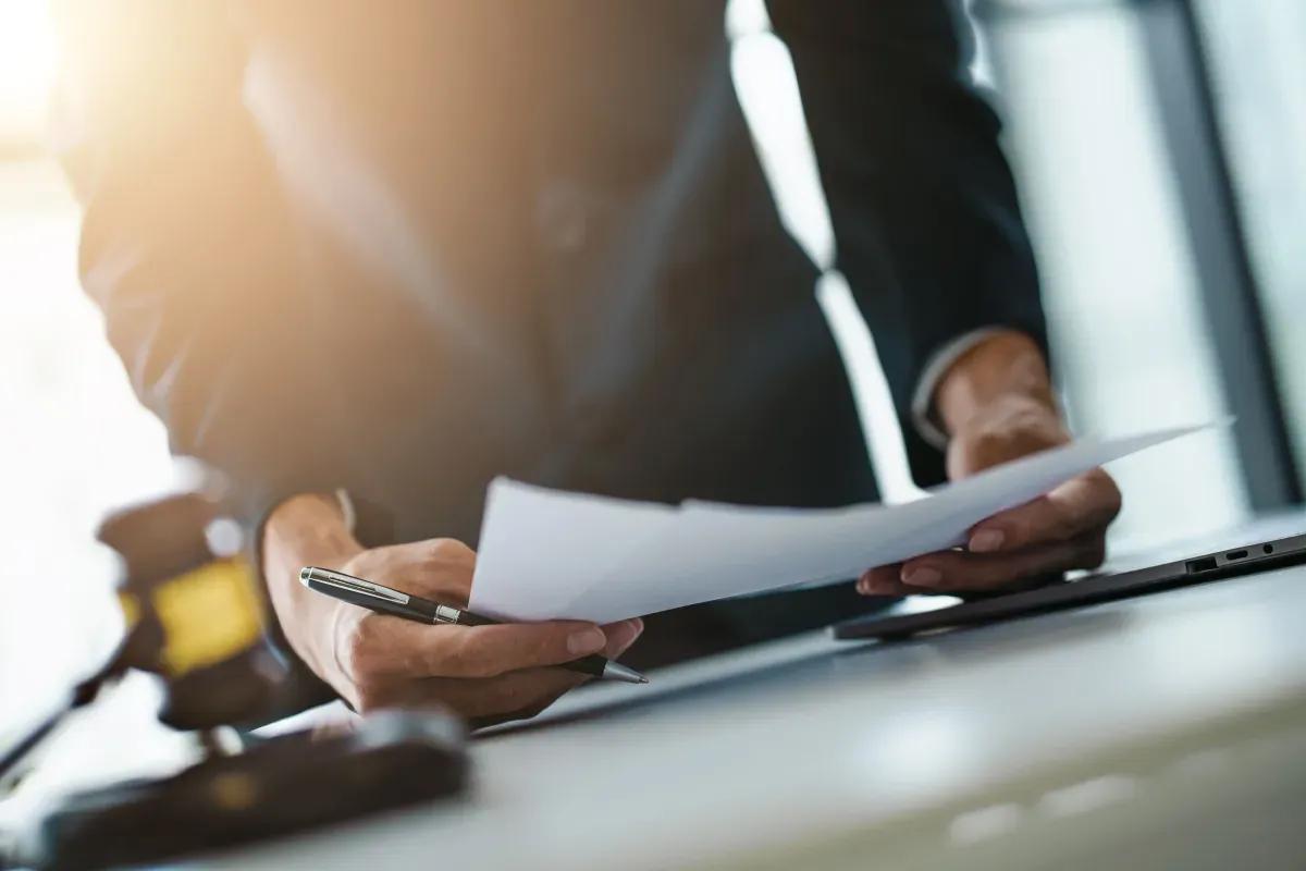 Um homem est segurando uma caneta e um pedao de papel